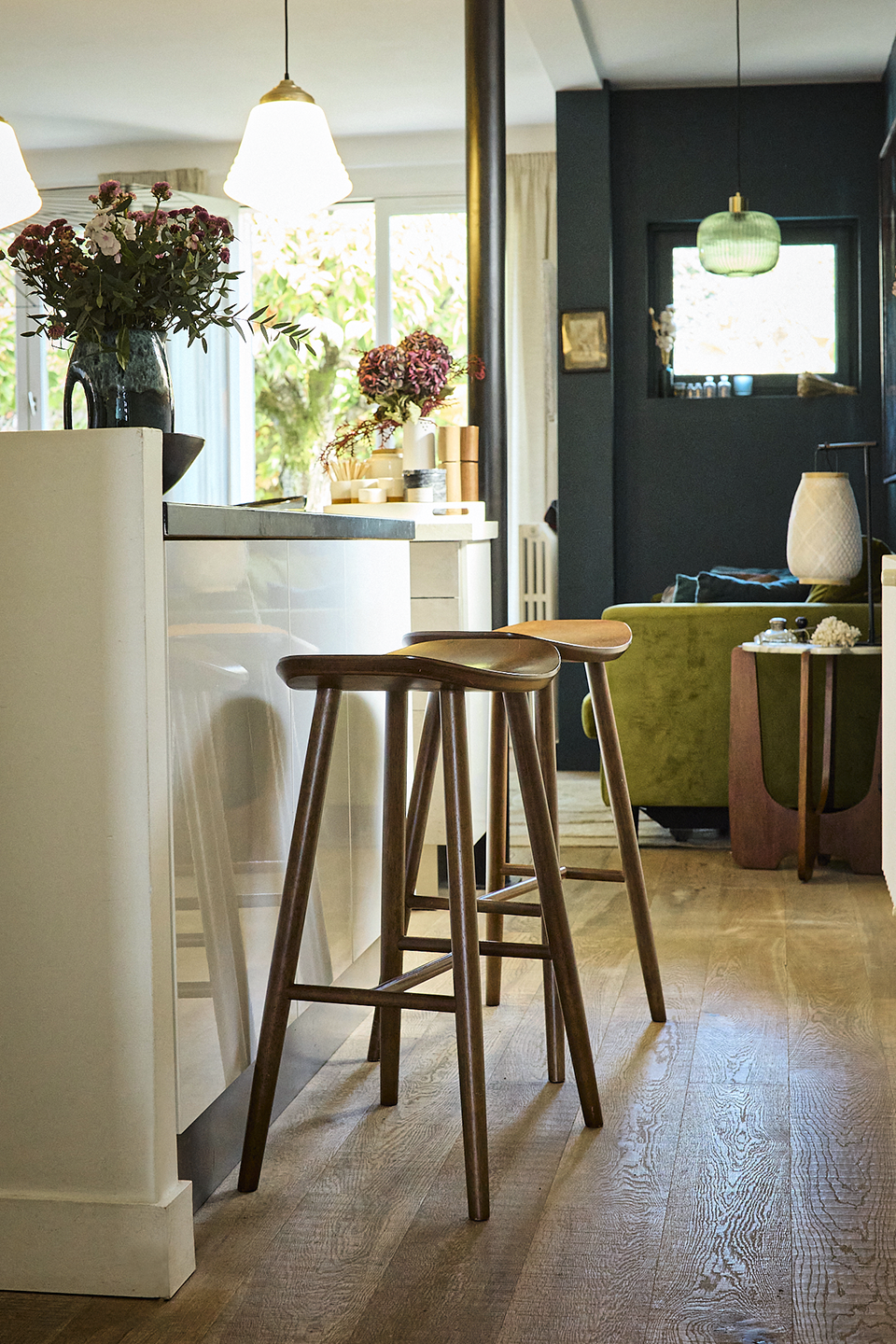 Tabourets en bois et ouverture de la cuisine sur le salon